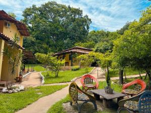 een picknicktafel en stoelen in de tuin bij Encanto do Parque Hospedagem in Lençóis