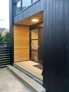 a house with a black wall and a wooden door at house with a view in Vikeså