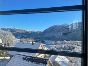 a view of a snowy mountain range from a window at house with a view in Vikeså