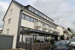 a white building with a car parked in front of it at Hotel Royal in Bad Salzuflen