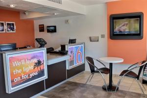 a waiting room with a tv and a table and chairs at Motel 6-Coalinga, CA - East in Coalinga