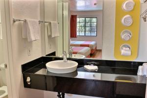 a bathroom with a sink and a bedroom with a bed at Motel 6-Coalinga, CA - East in Coalinga +55 photos