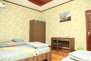 a room with two beds and a desk and a table at Yellow Hostel Dushanbe in Dushanbe