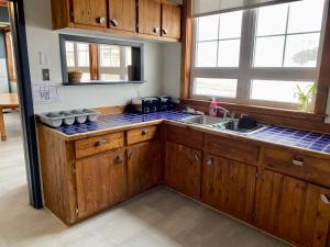 a kitchen with wooden cabinets and a sink at Auberge de Gros-Cap in Cap-aux-Meules