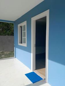 a room with a blue wall and an open door at Pousada Raio de Sol - Ilha de Itaparica- Catu á 150 m da praia in Vera Cruz de Itaparica