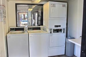 a laundry room with white washer and dryers at Motel 6-Coalinga, CA - East in Coalinga