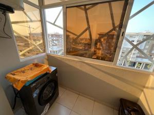 uma máquina de lavar roupa num quarto com duas janelas em Appart de luxe 27 ILOT9 em Oujda