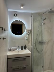 a bathroom with a sink and a shower with a mirror at Domek Bałtycki Lux in Rewa