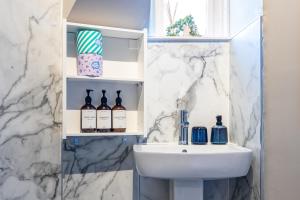 a bathroom with a sink and a white marble wall at The Tartan Terrace in Inverness