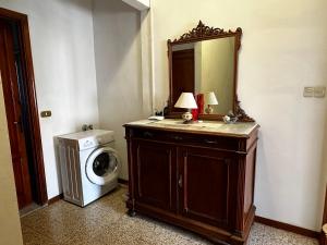 uma casa de banho com uma máquina de lavar roupa e um espelho. em Casa Valentina em Capannori