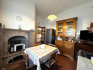 uma sala de jantar com uma mesa e uma lareira em Casa Valentina em Capannori