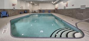 a large swimming pool in a building with chairs at Vittoria Hotel & Suites in Niagara Falls