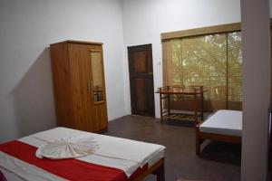 um pequeno quarto com uma cama e uma janela em Extream Adventures of Sri Lanka em Kitulgala