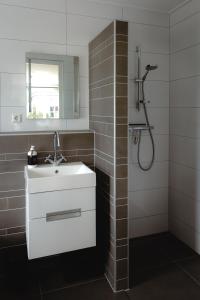 a bathroom with a white sink and a shower at B&B Het Rijgebint in Molenaarsgraaf