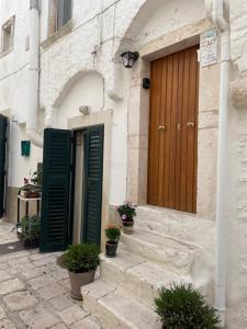 a building with a wooden door and some stairs at La Dimora nel Borgo in Locorotondo