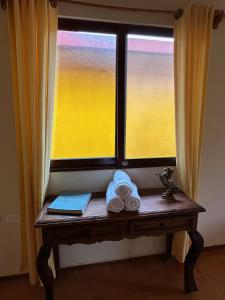 una mesa frente a una ventana con toallas y un libro en LA QUINTA 