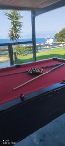 a pool table with two pool sticks on it at Koralli Sea View Hotel in Kato Achaia