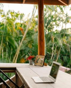een laptop op een tafel met een foto bij Salty Enthusiasts Share House & Villas in Santa Teresa Beach