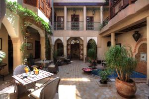 un patio con mesas y sillas y un edificio en Riad Zayane, en Marrakech