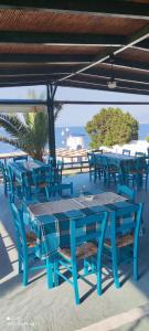 un ensemble de tables et de chaises bleues sur une terrasse dans l'établissement Koralli Sea View Hotel, à Kato Achaia
