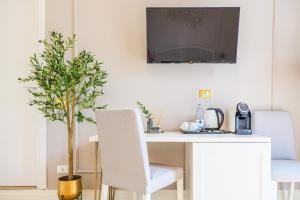 a white desk with two chairs and a potted plant at L'Opera Rooms & Suite in La Spezia