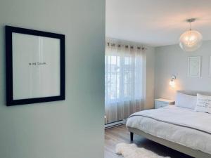 - une chambre avec un lit et une photo sur le mur dans l'établissement Luxury Home with Gym, Sauna, Patio, and AC, à Halifax
