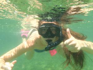 a woman in the water giving a thumbs up at Pousada Kaluana in Barra Grande