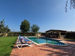 a group of lounge chairs next to a swimming pool at Amazing villa for big groups in the best place of Costa Brava in Palamós