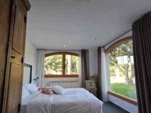 a woman laying on a bed in a bedroom with a window at Amazing villa for big groups in the best place of Costa Brava in Palamós