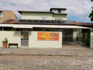 um edifício com painéis solares na lateral em Pousada Executiva SolRiso Aeroporto Florianópolis em Florianópolis