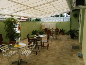 a patio with tables and chairs in a building at Pousada Executiva SolRiso Aeroporto Florianópolis in Florianópolis