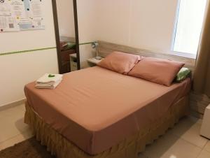 a bed in a room with pink pillows at Pousada Executiva SolRiso Aeroporto Florianópolis in Florianópolis