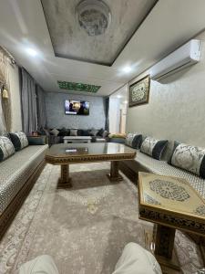 a living room with a couch and a table at appart luxe CORALIA 34 IL 7 in Oujda