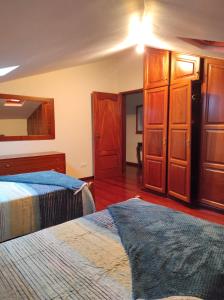 a bedroom with two beds and wooden cabinets at Casa Câmara in Arco da Calheta