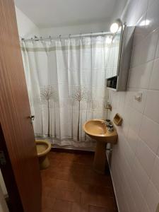 uma casa de banho com um lavatório, um WC e uma cortina de chuveiro. em Departamento en Mar del Plata em Mar del Plata