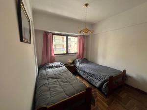 um quarto com 2 camas e uma janela em Departamento en Mar del Plata em Mar del Plata