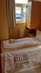 Cette chambre comprend 2 lits et une fenêtre. dans l'établissement Villa Seegatt Wohnung 008, à Norderney