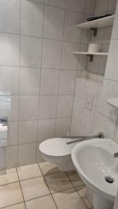 La salle de bains blanche est pourvue de toilettes et d'un lavabo. dans l'établissement Villa Seegatt Wohnung 008, à Norderney