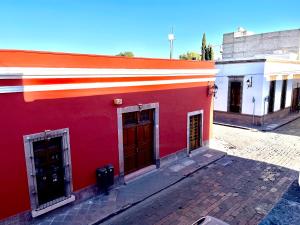 a red and orange building on a street at La casona del Centro Hist. in Querétaro
