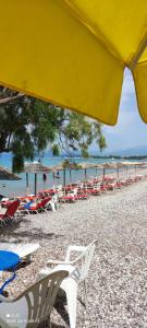 a group of chairs and tables on a beach at Koralli Sea View Hotel in Kato Achaia