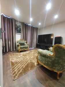 a living room with two chairs and a flat screen tv at Crestfield Lodge in Thamesmead