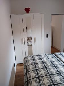 a bedroom with a bed with a heart on the wall at HARZ-LIEBE Lautenthal in Langelsheim