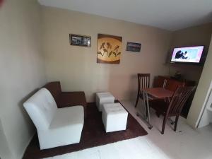 sala de estar con muebles blancos y TV en Departamento a un paso del Metropolitano y Miraflores, en Lima