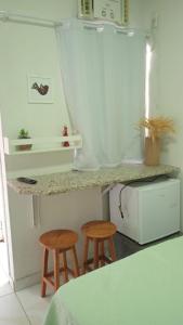 uma cozinha com dois bancos e um balcão em POUSADA MEGA em Marataízes