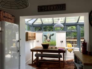 a kitchen with a table and a picture of a cow at Daisy Cottage, delightful 3 bedroom cottage in village location in Barrowford
