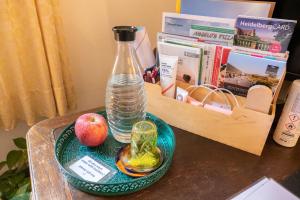 a bottle of water and an apple on a table at Zimmer in Künstlerwohnung in Stuttgart