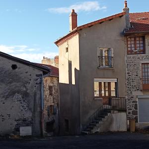 un edificio antiguo con una escalera delante en Le Repose Pieds, en Le Monastier sur Gazeille