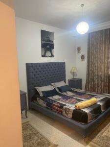 um quarto com uma cama grande e uma cabeceira de metal em Studio cité elwahat em La Marsa