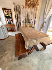 um quarto com uma cama e uma mesa de madeira em Flat Xainã em Taipu