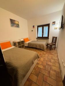 a bedroom with two beds and a table and a chair at Locanda delle sorelle in Campagnano di Roma